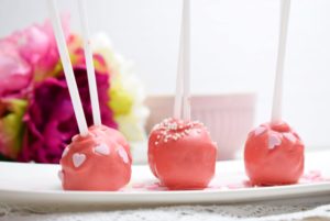 Rote Cake Pops dekoriert mit Perlen und Zuckerherzen